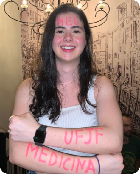 Estudante aprovada exibindo cartaz.