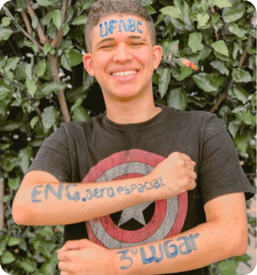 Estudante aprovado exibindo cartaz.