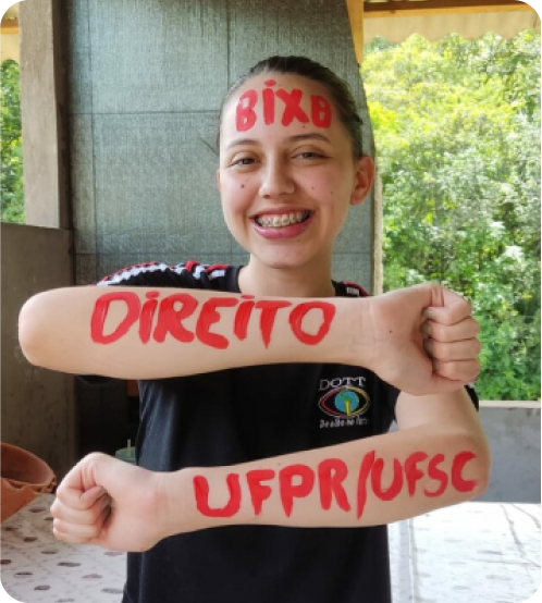 Estudante aprovada exibindo cartaz.